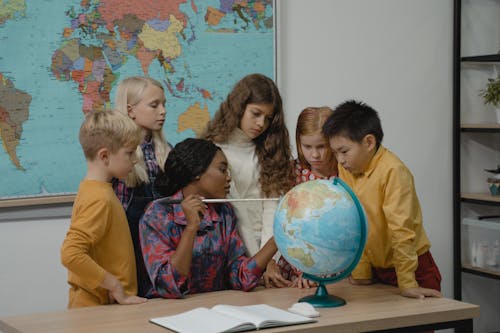 Teacher teaching students about Geography using a Globe