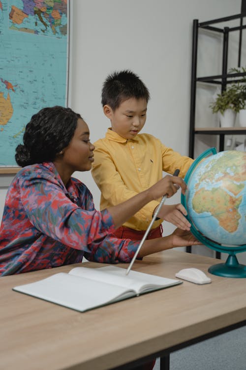 Teacher teaching a Student about Geography using a Globe