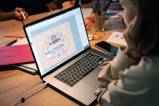 在室内用笔记本电脑做万圣节平面设计的人