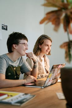 Two young professionals brainstorming together in a modern workspace with natural light.