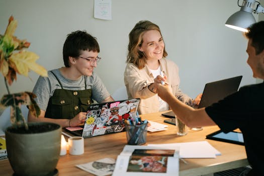 A group of young professionals collaborating in a well-lit office setting, focusing on a project.