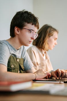 Two young professionals focused on a project in a modern workspace.