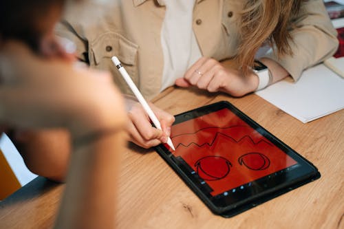 Free Person Drawing a Jack O'Lantern on a Tablet Stock Photo