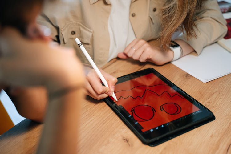 Person Drawing A Jack O'Lantern On A Tablet