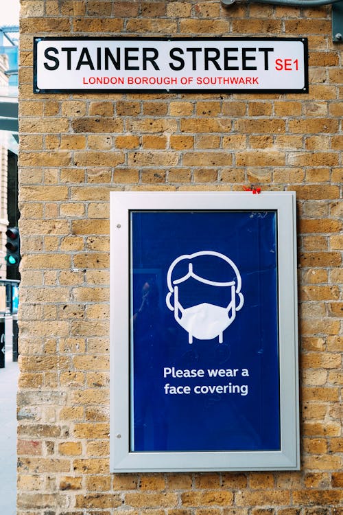 Signboard with reminder to wear face mask on building wall