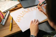 有人在木桌上用记号笔和笔记本设计以青少年为主题的纸上艺术作品