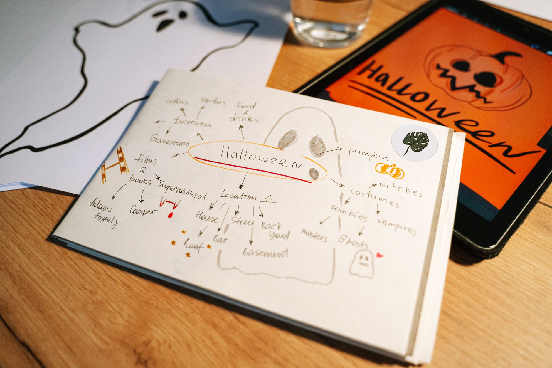A Halloween-themed planning session featuring ghost drawings and digital projects on a tablet.