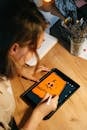 Person Drawing a Jack O'Lantern on a Tablet