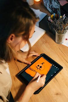 一名女子用平板电脑绘制南瓜灯，激发万圣节创意