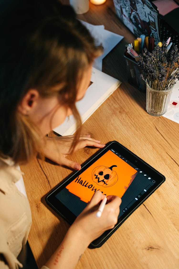 Person Drawing A Jack O'Lantern On A Tablet