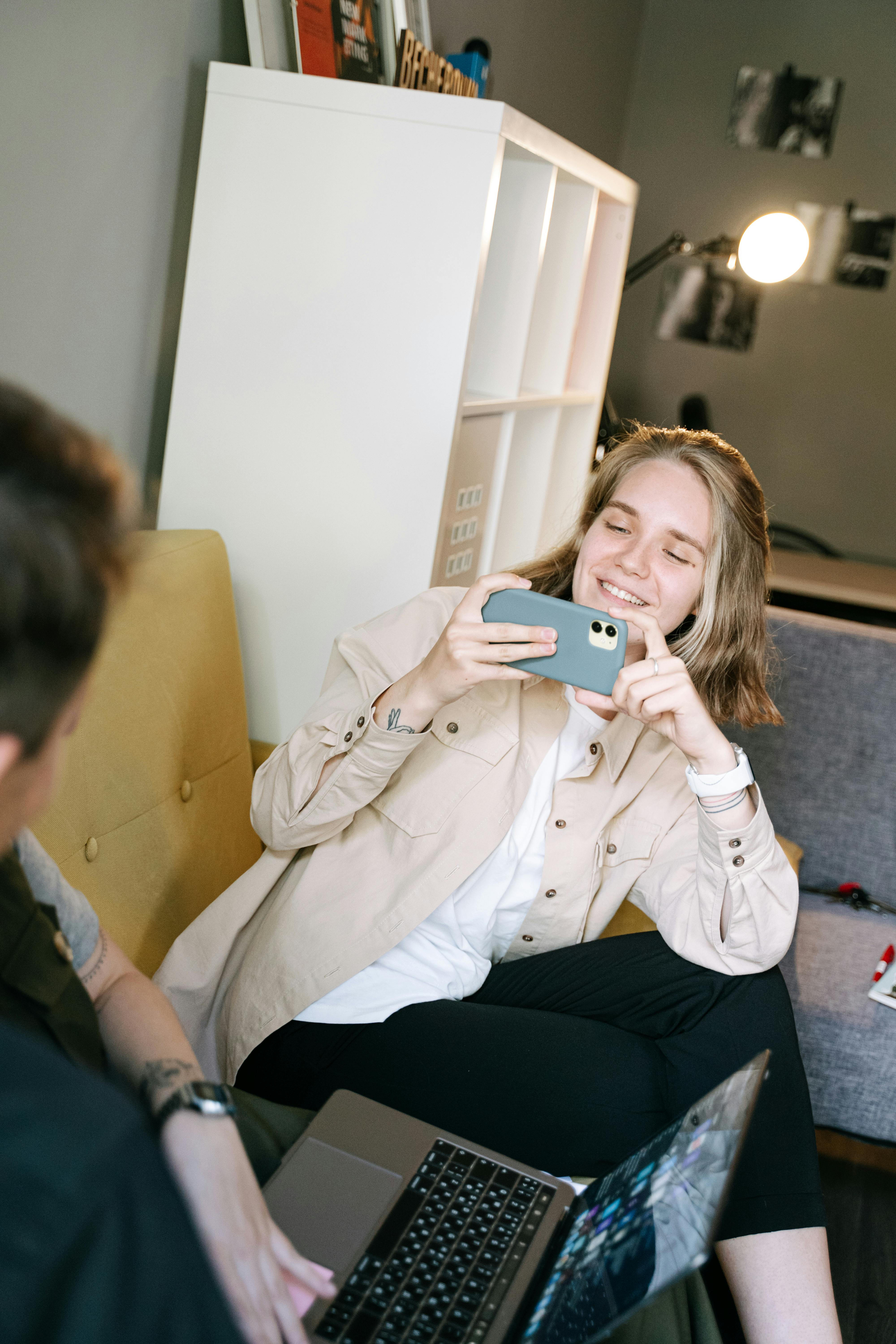 woman in white coat holding iphone