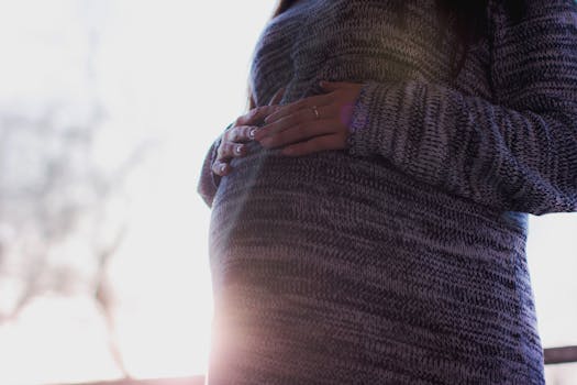 Pregnant Woman Wearing Marled Gray Sweater Touching Her Stomach