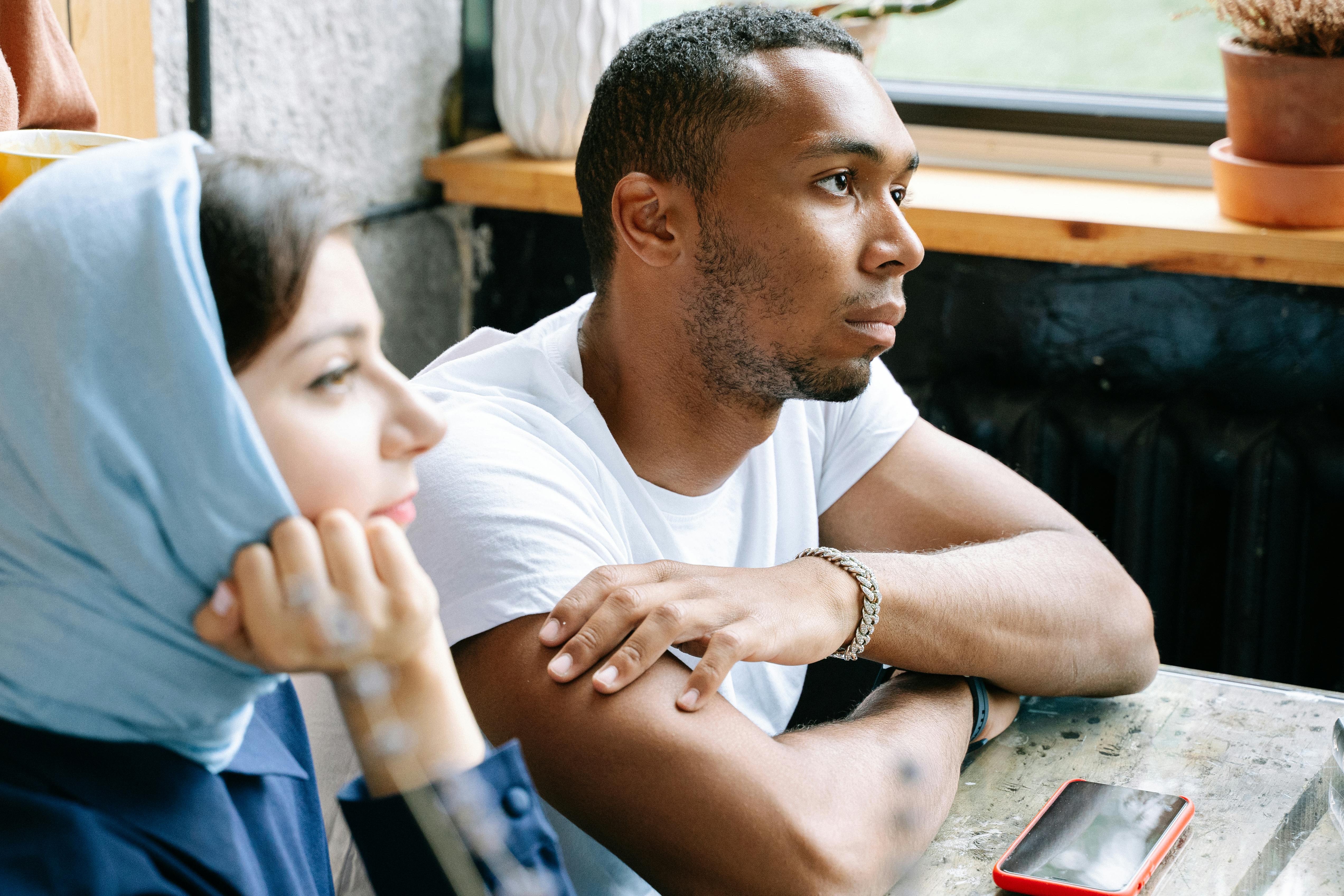 两名同事在一家舒适的咖啡馆里交谈，展现了多样性和团队合作