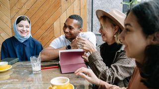 A group of friends sharing a joyful moment over coffee in a cosy cafe