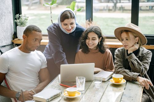 Free A diverse group of coworkers collaborating on a laptop in a cozy office setting. Stock Photo
