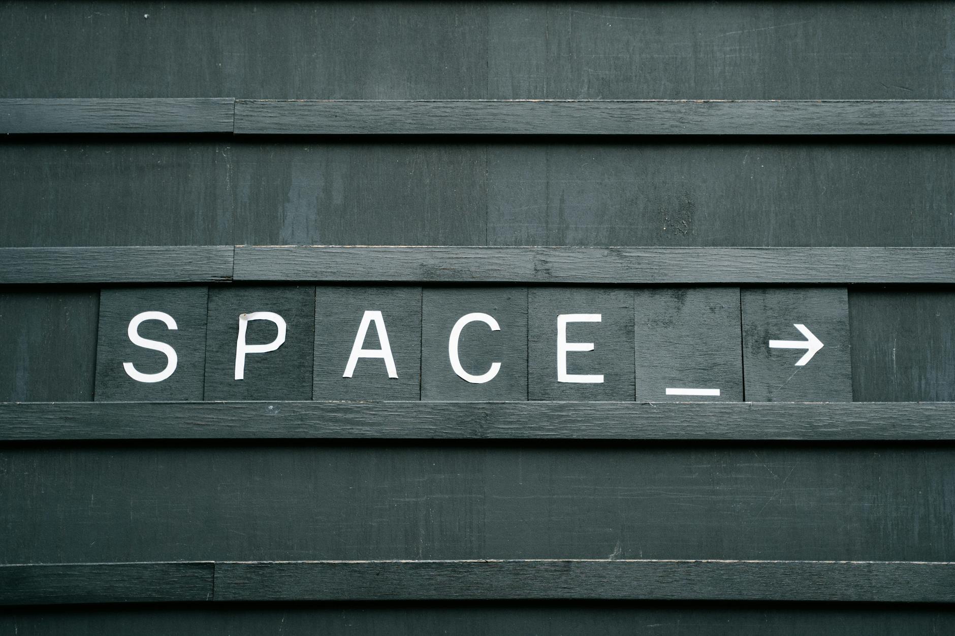 Close-up of a minimalist wooden sign with 'SPACE' in capital letters and an arrow, creating a conceptual theme.