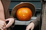 南瓜以雕刻的脸和舒适的外套装饰秋日，非常适合万圣节的感觉