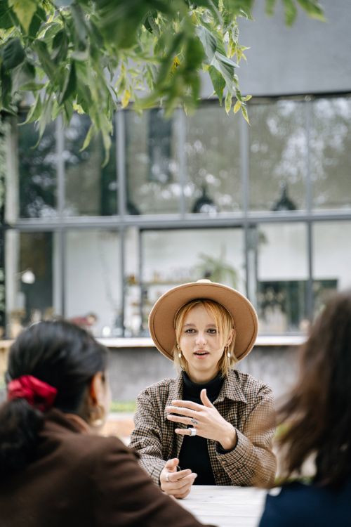 Free Three women engaged in conversation outdoors, embracing diversity. Stock Photo
