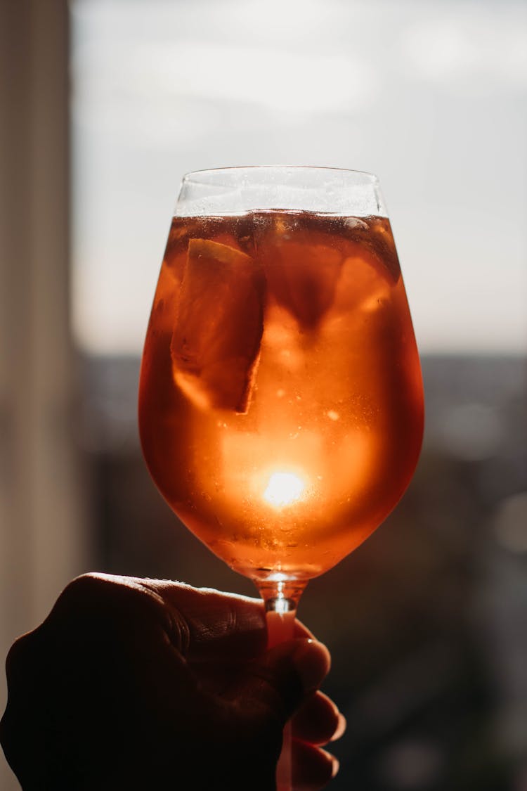 Person Raised Hand With Glass Of Cocktail