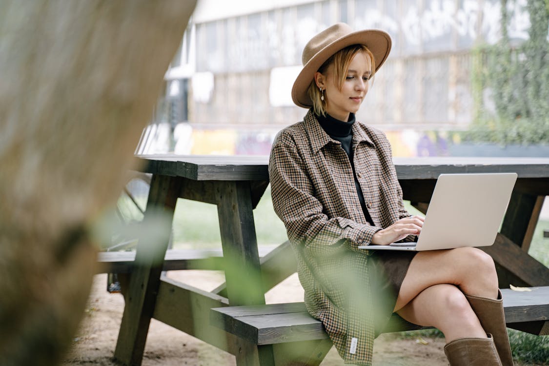 Free Woman in Plaid Shirt Using a Laptop Stock Photo