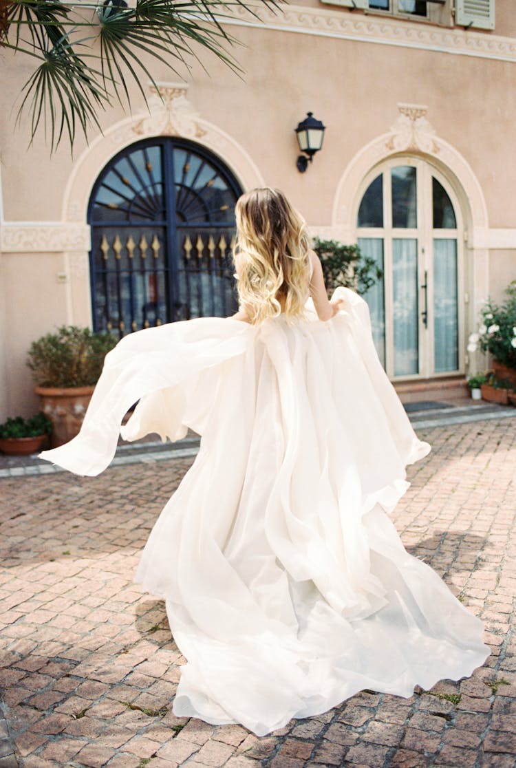 A Woman In White Dress Standing Paved Floor