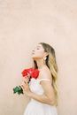 Woman in White Spaghetti Strap Top Holding Red Flowers