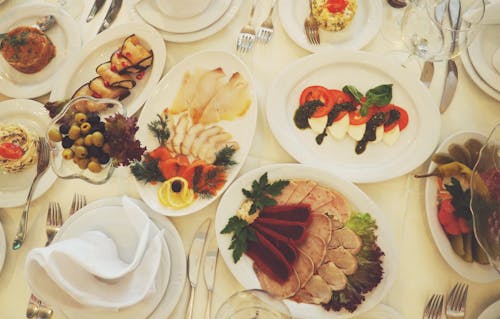 テーブルの上の白いセラミック楕円形プレートで提供される各種料理