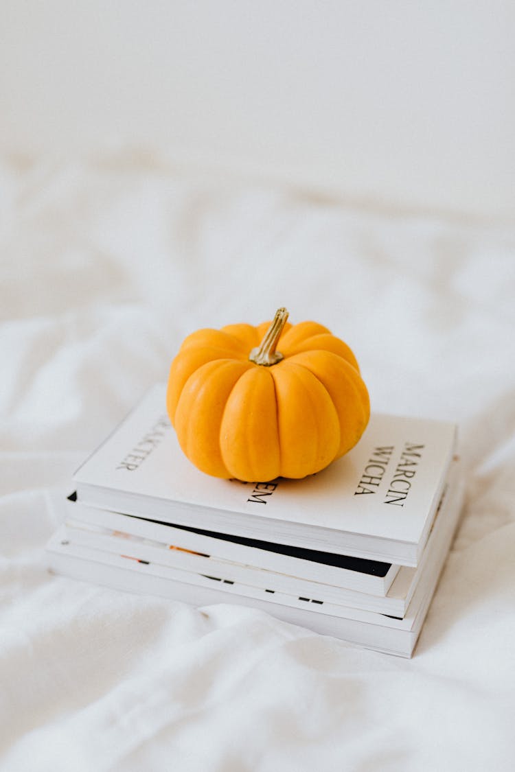 Yellow Pumpkin On Stacked Books 