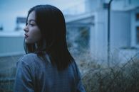 黄昏时分，一位少女在静谧的城市中若有所思地凝视着远方