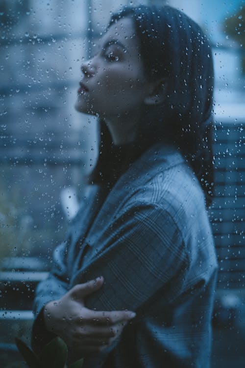 Unhappy thoughtful teen girl arms crossed in rainy day