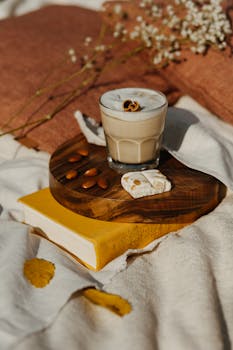 一杯温暖质朴的拿铁咖啡，配上杏仁和饼干，放在舒适的毯子上，非常适合休闲主题