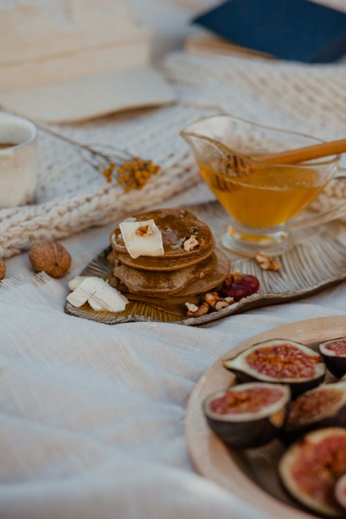 Free A cozy breakfast scene with pancakes, honey, and fresh figs on a soft table setting. Stock Photo