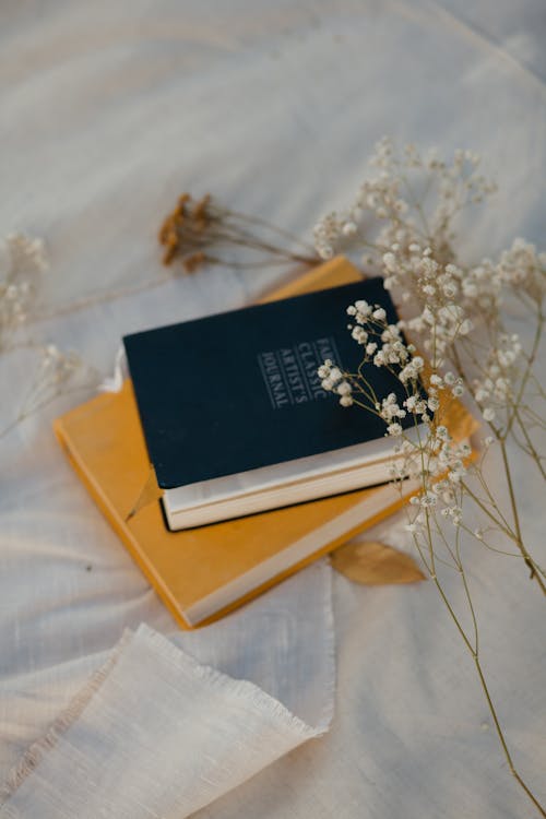 Stacked Book  on White Textile 