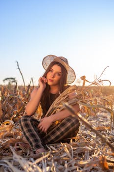 A young woman posing in a cornfield during sunset in Arcos, Brazil, with a rustic vibe.