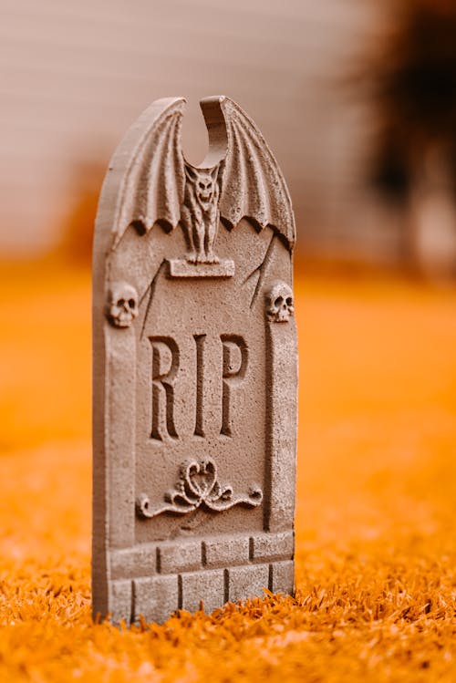 Gray tombstone on grass in yard