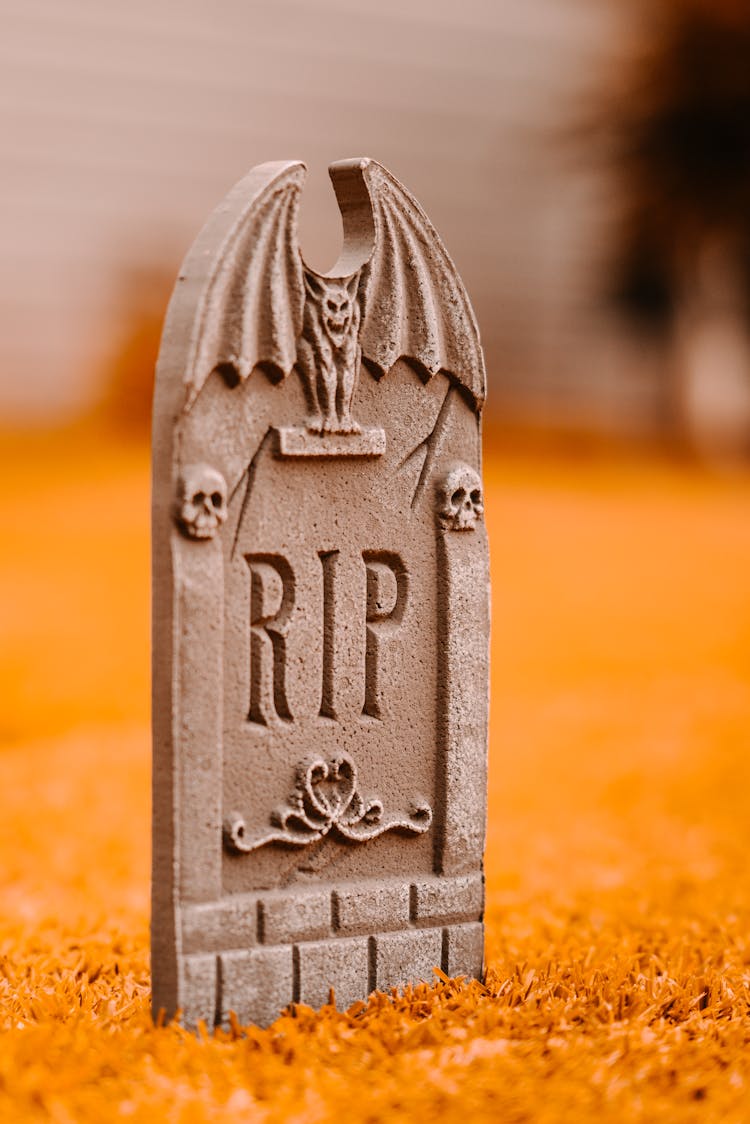 Gray Tombstone On Grass In Yard