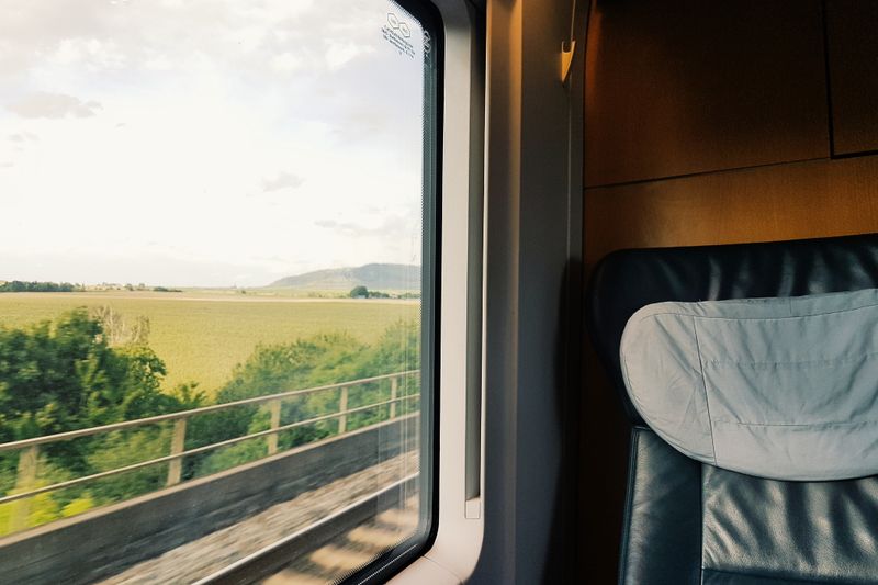 Captivating view of the countryside from a train window during daylight.
