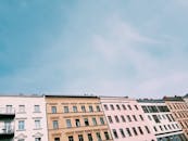 这张照片以低角度拍摄现代城市公寓楼，在晴朗的蓝天下展现了建筑设计之美