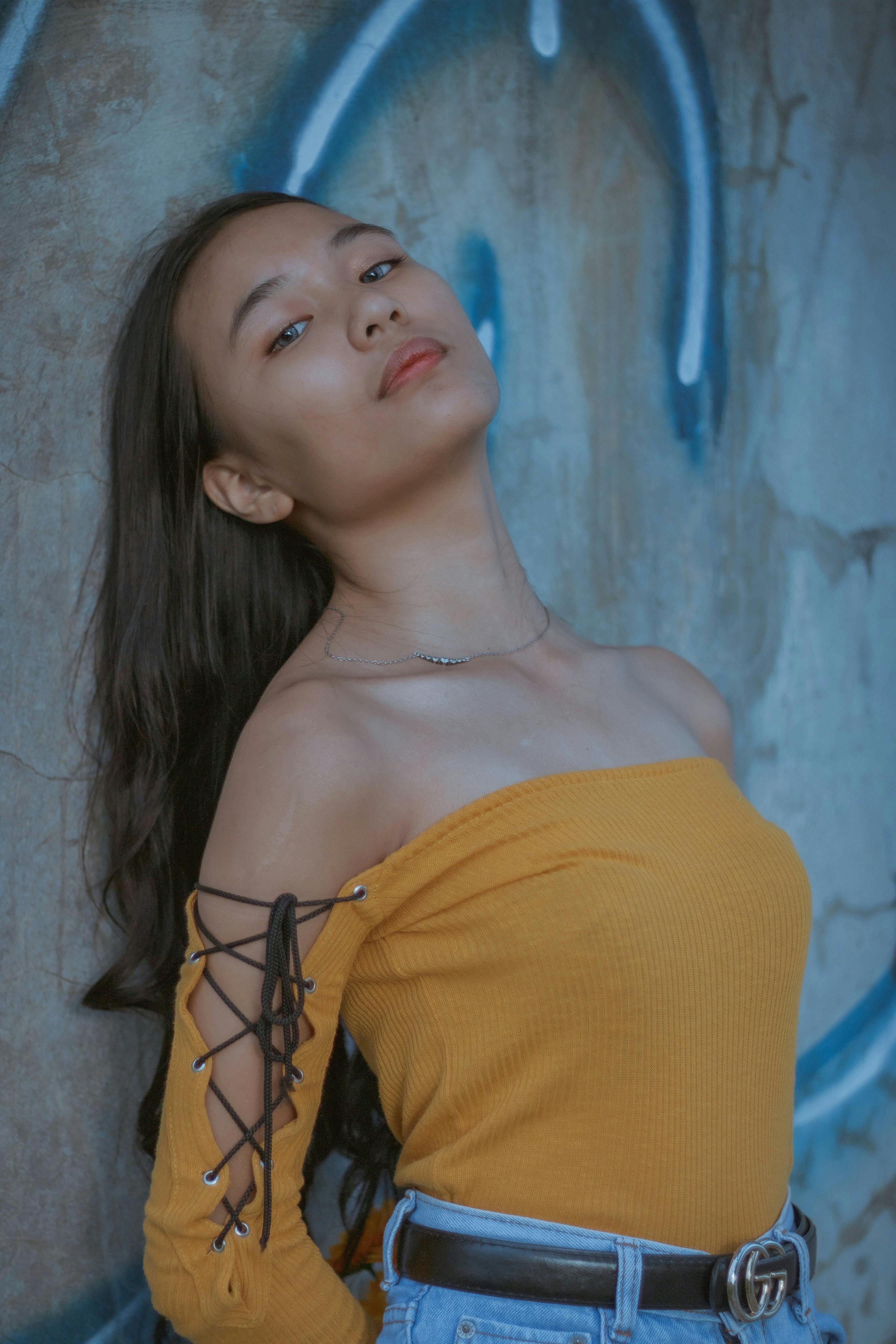 Side view of Asian female standing at building corner · Free Stock Photo