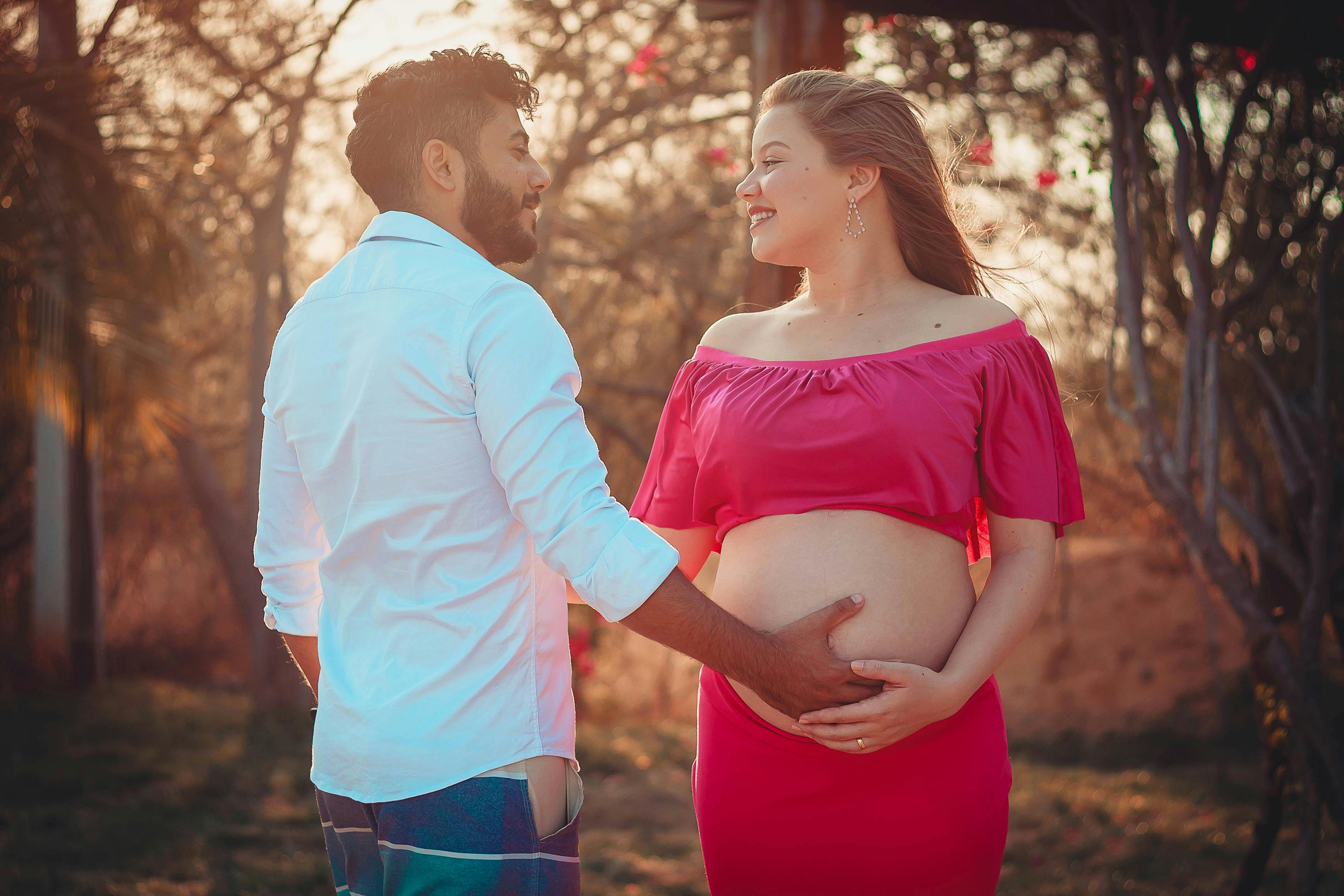 happy ethnic man touching belly of pregnant woman