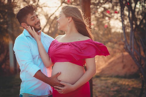 Ethnic man with pregnant woman in nature