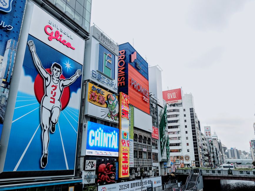 Vibrant advertisements in Dotonbori district, Osaka capturing the lively urban scene with the famous Glico Man sign.