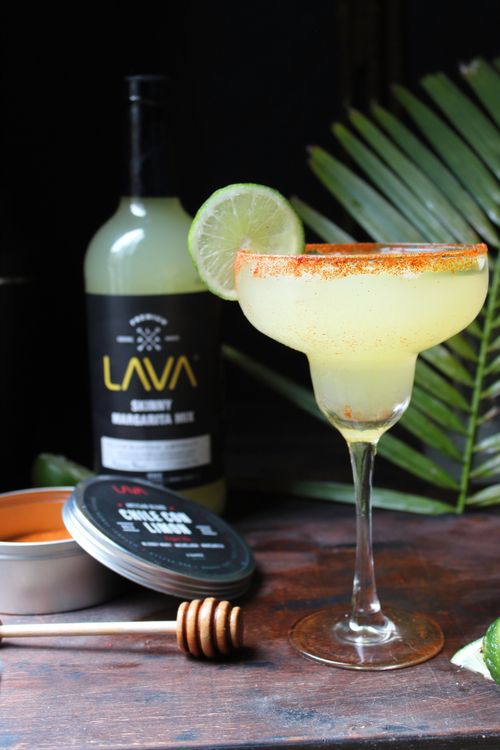 Free Inviting margarita cocktail garnished with lime and chili powder, accompanied by a honey dipper and shaker. Stock Photo