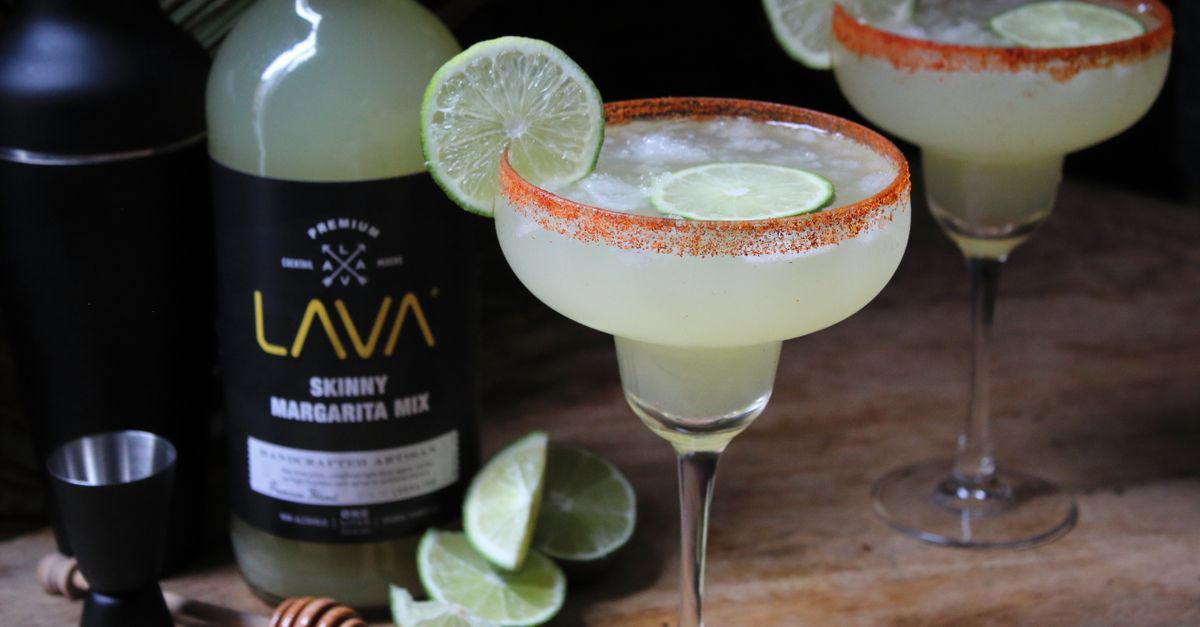 Close-up of a refreshing margarita with lime slice on a wooden table, ready to enjoy.