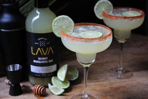 Free Close-up of a refreshing margarita with lime slice on a wooden table, ready to enjoy. Stock Photo
