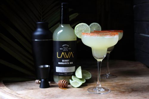 Free Lime margaritas with salt rim on wood featuring Lava mixer bottle. Perfect for cocktail enthusiasts. Stock Photo