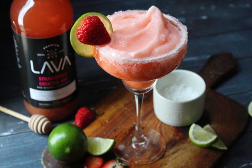 Free Chilled strawberry margarita with lime and strawberry garnish on wooden board. Perfect for cocktail enthusiasts. Stock Photo