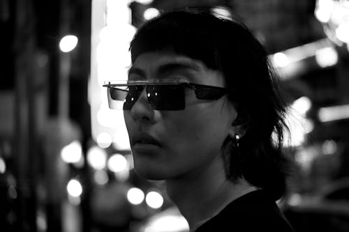 Stylish Asian man in sunglasses standing on street