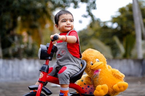 Cute Child riding a Bike Toy carrying Stuffed Toys