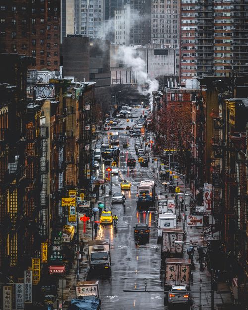 Free Aerial view of busy downtown Chinatown street in New York City during rainy day with taxis and buildings. Stock Photo